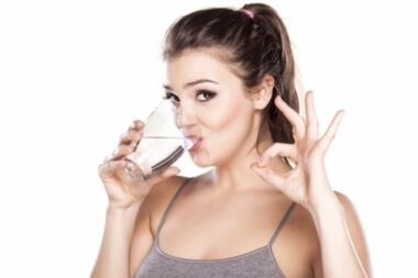 Das Mädchen trinkt sauberes Wasser